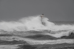 Faro di Mangiabarche avvolto dagli spruzzi del mare in burrasca