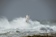 Faro di Mangiabarche avvolto dagli spruzzi del mare in burrasca