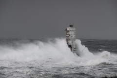 Faro di Mangiabarche avvolto dagli spruzzi del mare in burrasca