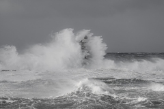 Faro di Mangiabarche avvolto dagli spruzzi del mare in burrasca
