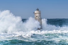 Faro di Mangiabarche avvolto dagli spruzzi del mare in burrasca