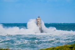 Faro di Mangiabarche avvolto dagli spruzzi del mare in burrasca