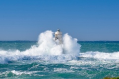 Faro di Mangiabarche avvolto dagli spruzzi del mare in burrasca