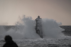 Faro di Mangiabarche avvolto dagli spruzzi del mare in burrasca