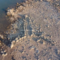 Le imponenti Tombe dei Giganti del Lago di Monte Pranu emergono tra le acque del bacino artificiale, visibili in condizioni di siccitร : un suggestivo frammento dellโantica civiltร nuragica nel cuore del Sulcis. Fotografia in luce diffusa delle Tombe dei Giganti del Lago di Monte Pranu: grandi lastre megalitiche disposte a formare un vestibolo semicircolare (esedra), che emergono dal terreno paludoso del bacino artificiale nella zona di Villaperuccio.